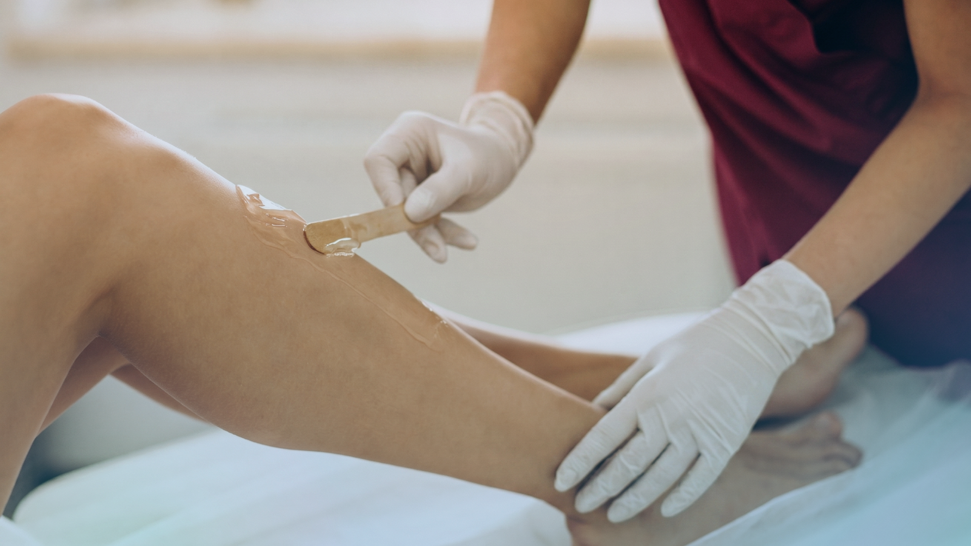 Especialista realizando depilación con cera fría con material de un solo uso